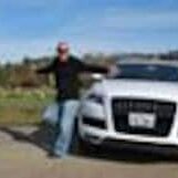 A man standing next to a white car.